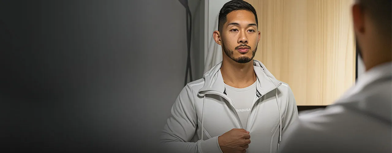 Man in a light-grey Hayabusa zip-up jacket over a white tee against a grey backdrop