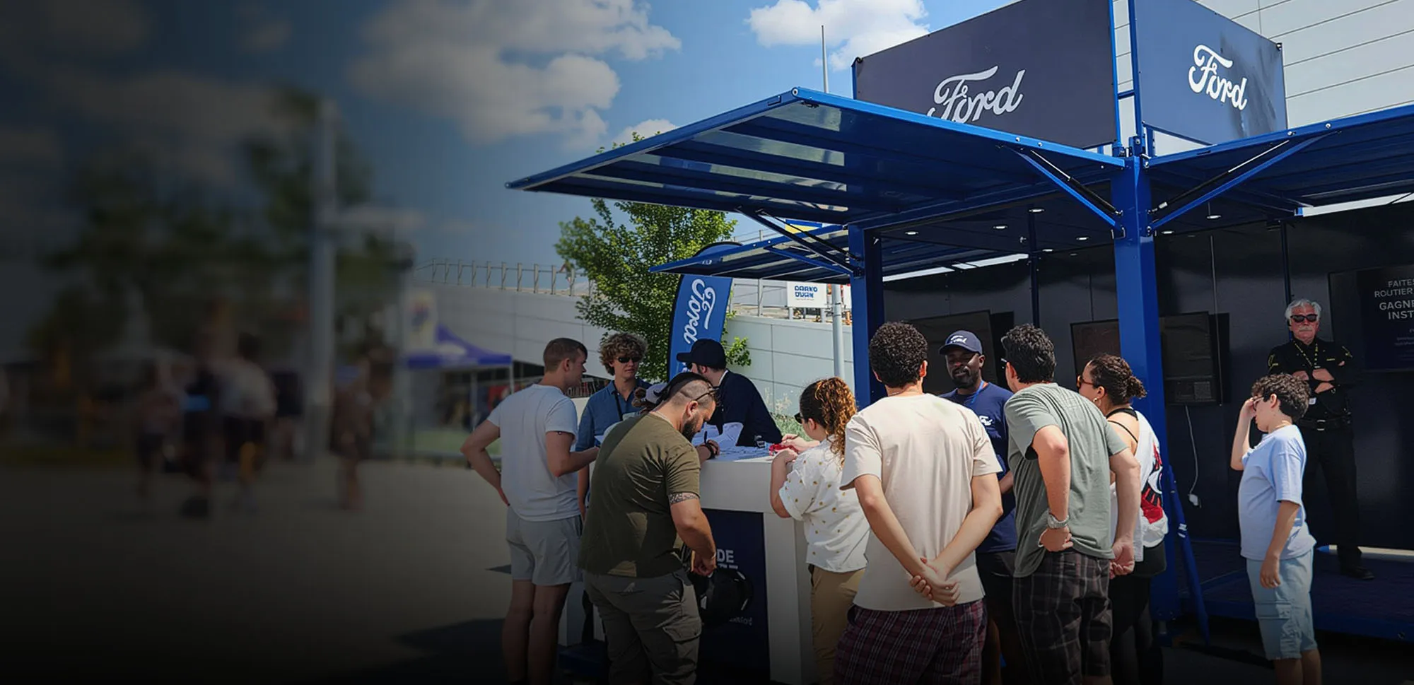 Crowd gathered at a blue Ford EV event booth