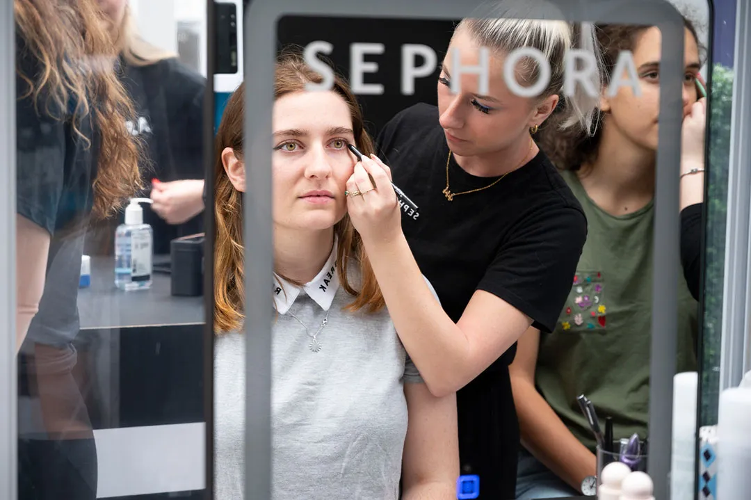 Makeup artist applying makeup to guest at activation