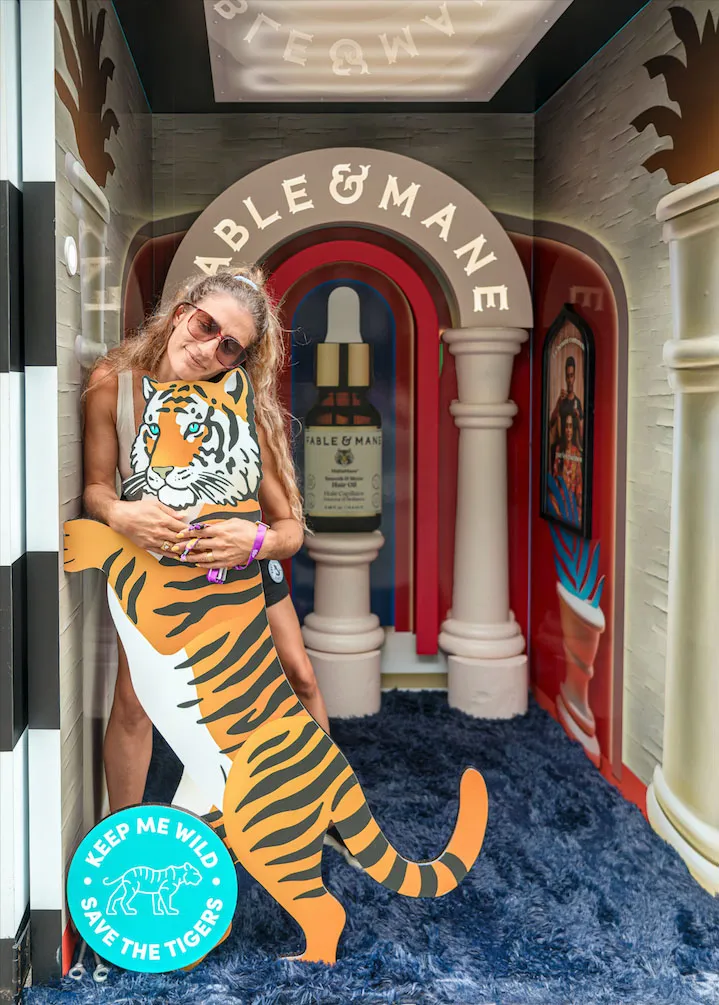Guest posing in Able & Mane aura photo booth with red arch
