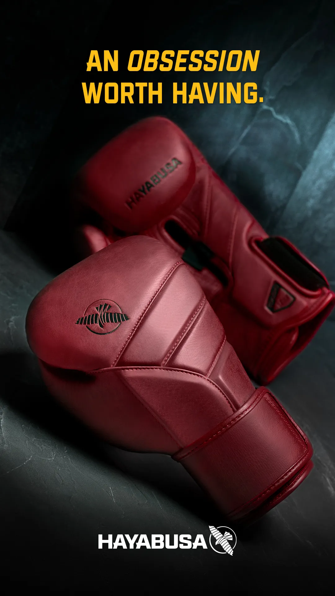 A pair of deep-red Hayabusa boxing gloves on a teal background