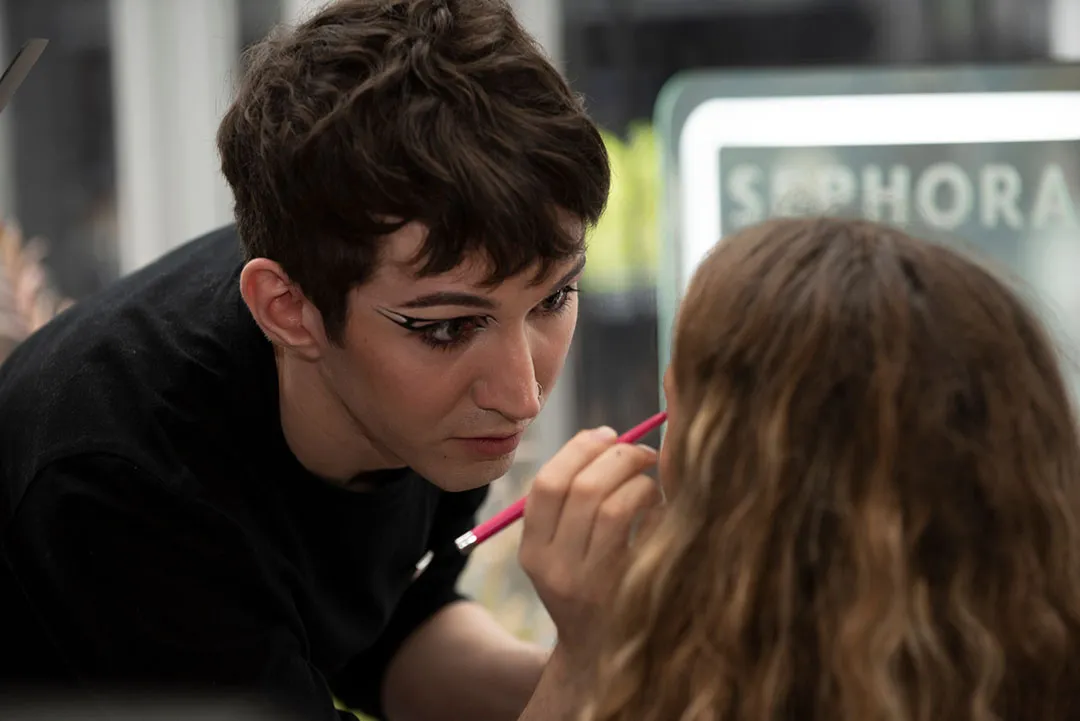 Makeup artist applying winged eyeliner to a guest