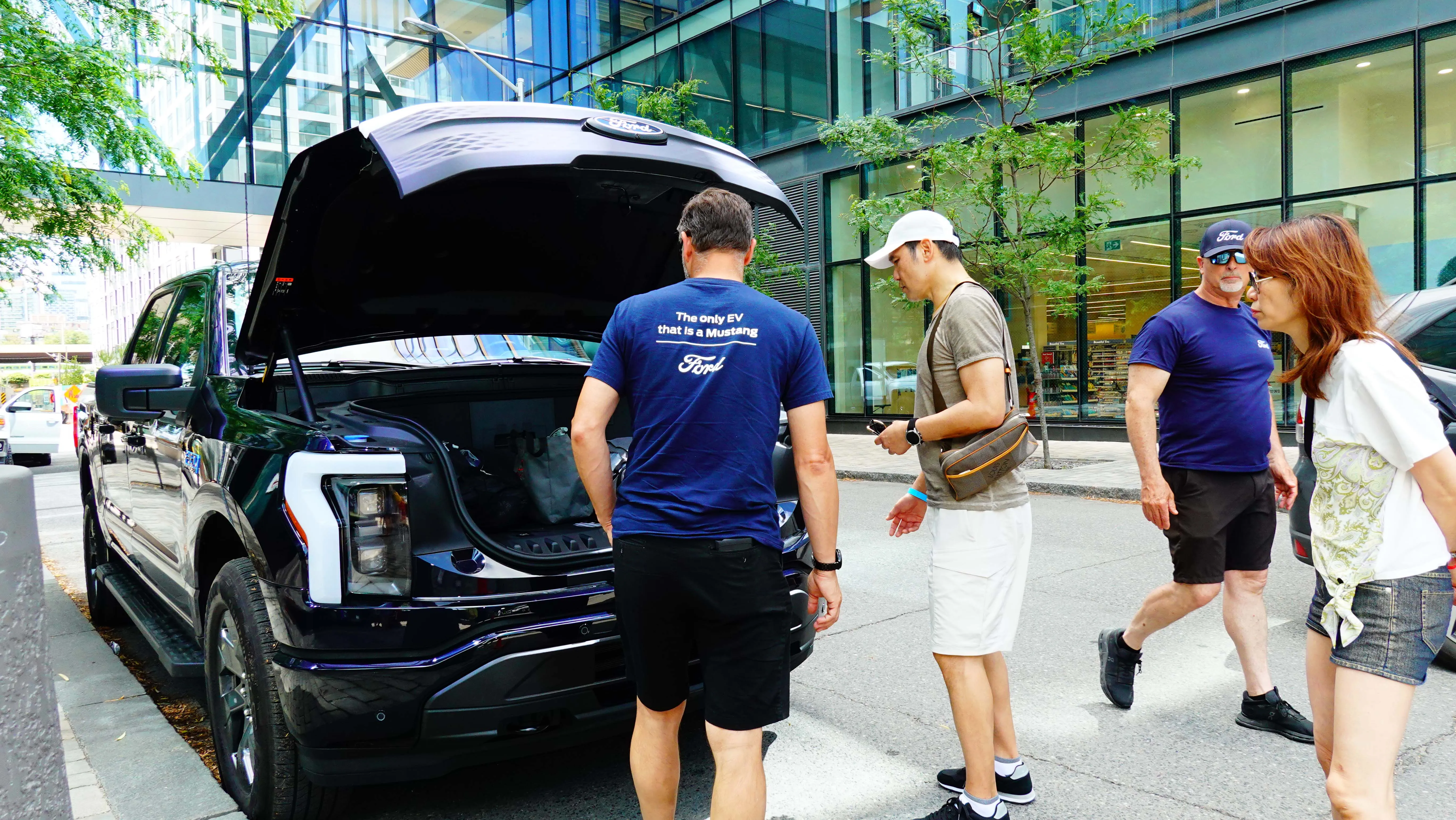 Ford staff member demonstrating electric vehicle features to visitors