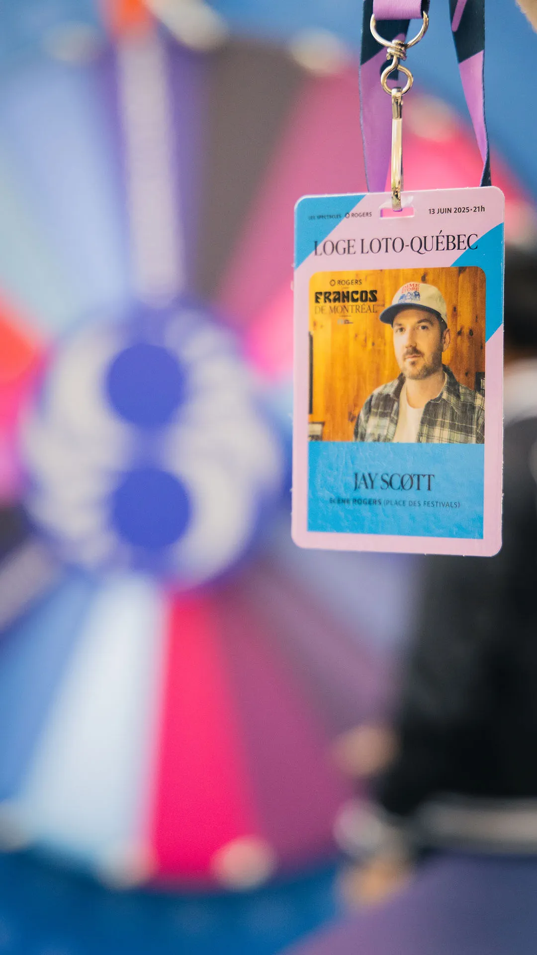 Event credential badge for Francos de Montréal hanging on a lanyard with performer photo and date