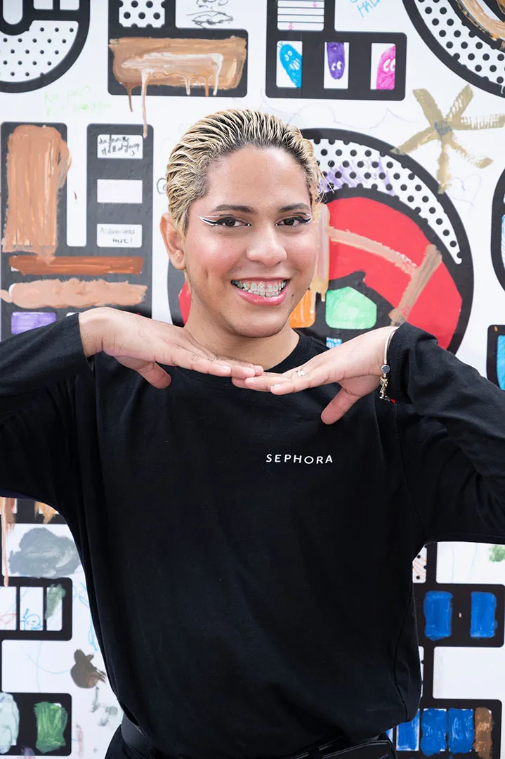 Smiling guest in a Sephora shirt at the art wall