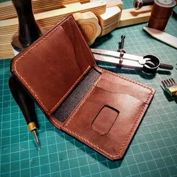 Hand-stitched leather bifold wallet on a cutting mat