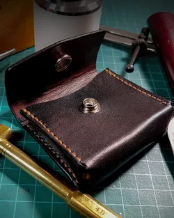 Dark leather card wallet with a snap closure