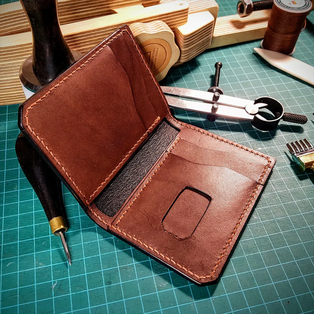 Open brown bifold wallet showing card slots and orange saddle stitching