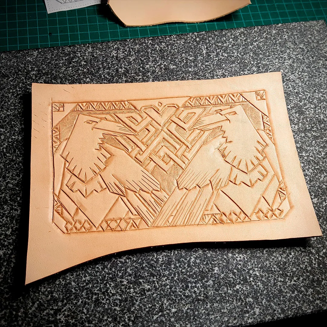 Undyed leather panel carved with a pair of ravens