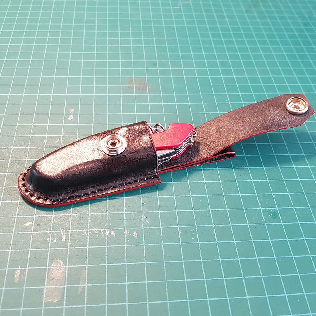 Finished sheath holding the folding knife on the workbench