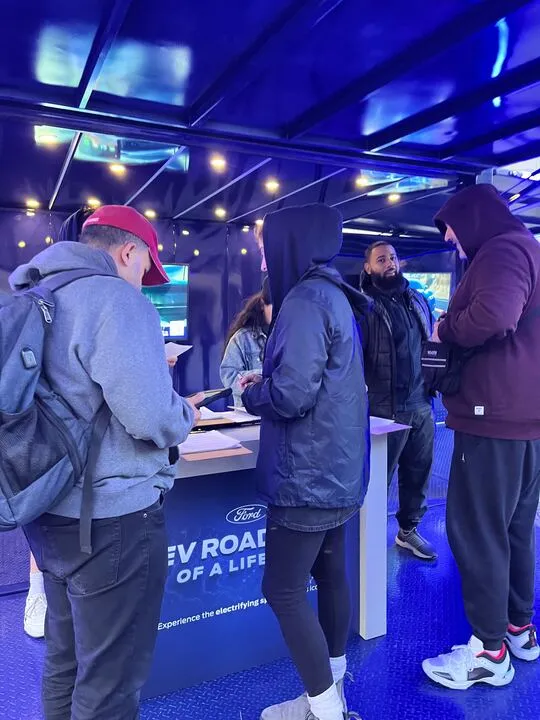 Event booth interior with staff and attendees at the counter